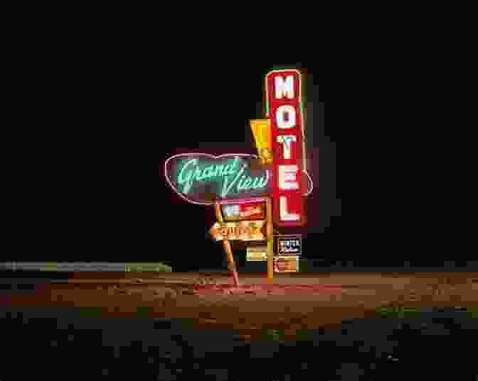 A Faded Yet Vibrant Neon Sign Adorns The Exterior Of A Classic Roadside Motel, Casting A Warm Glow Against The Night Sky. Neon Road Trip John Barnes